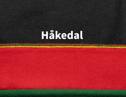 Grønn rullekant med rødt over. Øverst er det brodert to linjer med kjedesting i grønt og gult.